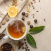 steaming cup of guarana tea surrounded by raw guarana seeds