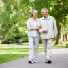 An active, healthy-looking older couple walking in park