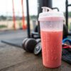 h23-prepare-drink Herbalife24 Prepare watermelon-colored pre-workout drink being stirred in a transparent shaker bottle