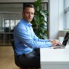 Professional man in his 40s sitting at an ergonomic desk, focused and productive
